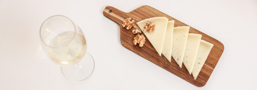 Una copa de vino blanco y tabla de queso preparada